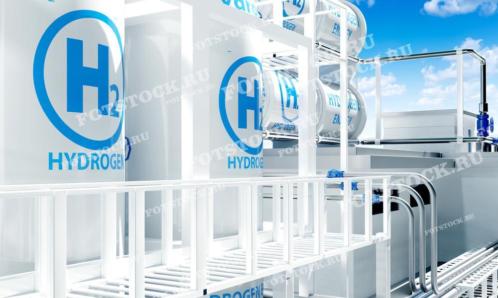 Фотография изображает водородные резервуары с надписью "H2" и "Hydrogen" на фоне голубого неба. Этот снимок подчеркивает использование водорода в качестве альтернативного и экологически чистого источника энергии для промышленных и энергетических целей.